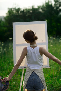 Rear view of woman standing on field