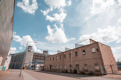 Low angle view of buildings against cloudy sky
