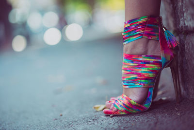 Low section of woman wearing colorful high heels