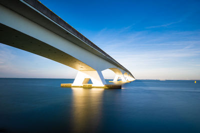 View of bridge over sea against blue sky