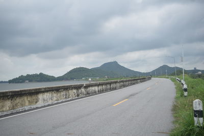 Empty road against cloudy sky