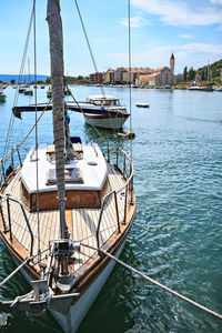 Sailboats moored in sea against sky