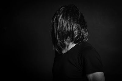 Close-up of woman against black background