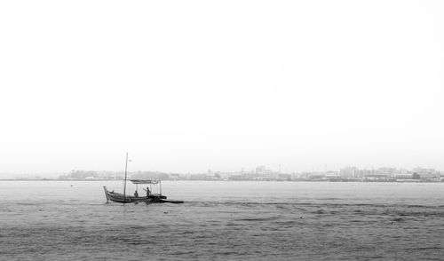 Sailboats in sea against sky