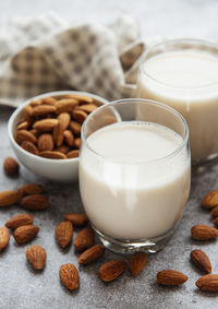 Glasses with almond milk and almonds on the table