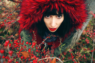 Woman wearing fur coat amidst red berries