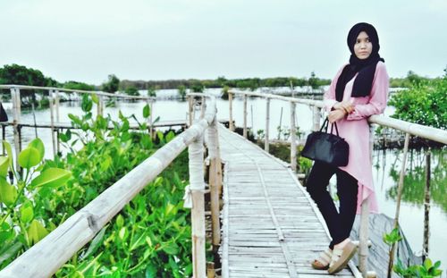 Woman standing on jetty in lake