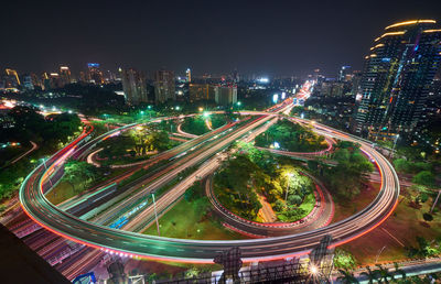 High angle view of illuminated city street and buildings at night