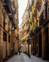 People walking on narrow street amidst buildings in town