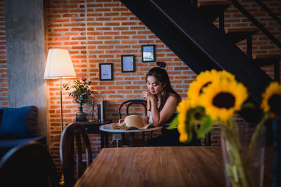 Woman sitting on table at sidewalk cafe