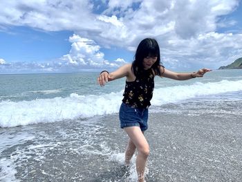 Full length of woman on beach against sky