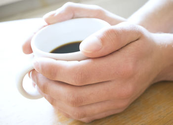 Close-up of hand holding cup of coffee