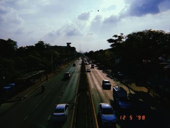 Cars on highway in city against sky