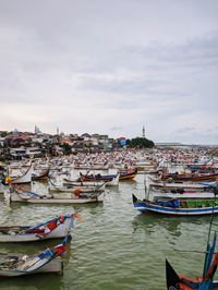 Boats moored in river against buildings in city