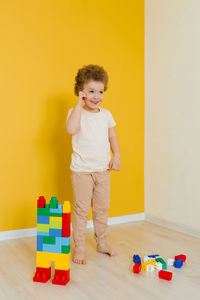 Child is playing with colorful cubes at the table. kid has fun and builds from bright construction