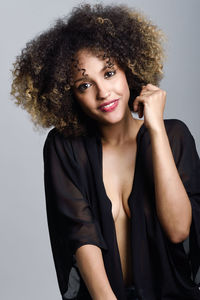 Portrait of smiling young woman against white background