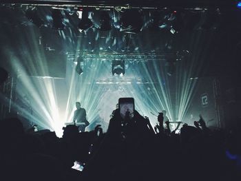 Rear view of people enjoying music concert at night