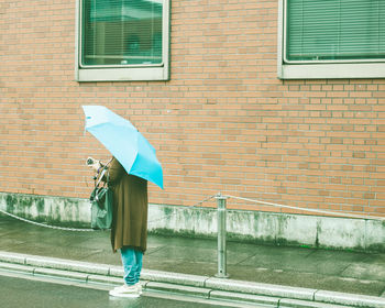 Full length of woman standing by window