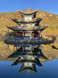 Gazebo in lake by building against sky