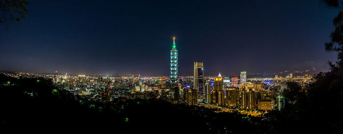 Illuminated buildings against sky at night