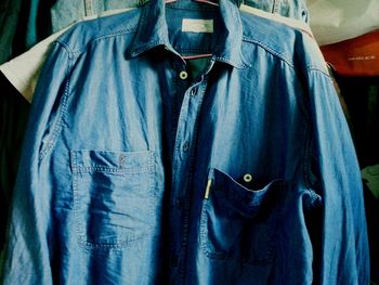 Close-up of clothes hanging on blue store