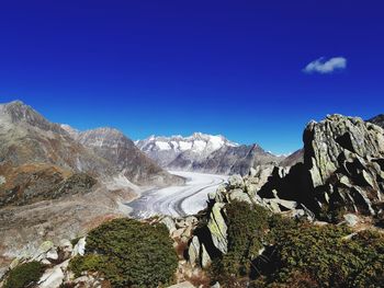 Scenic view of mountains against blue sky