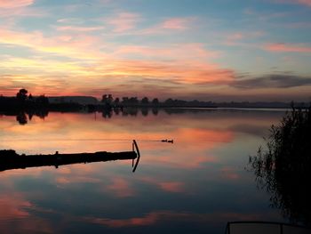 Scenic view of lake against orange sky