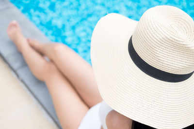 Low section of woman relaxing in swimming pool