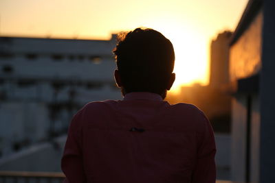 Rear view of man looking at sunset