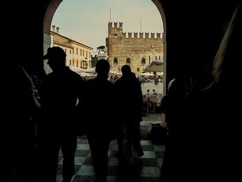 Silhouette people looking through window