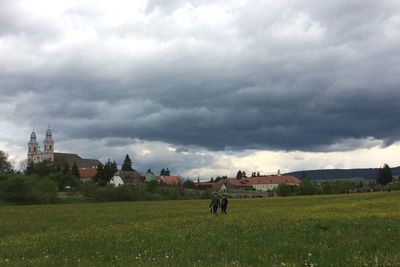 View of grassy field against cloudy sky