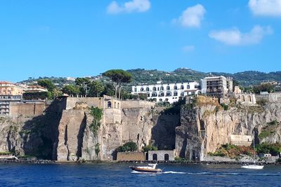 View of the coast of sorrento.  boats in sea against blue sky.