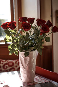 Close-up of roses in vase on table at home