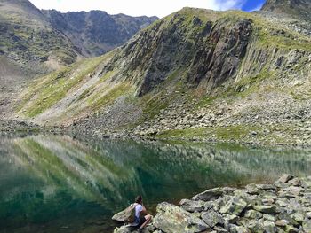 Man sitting on rock by lake