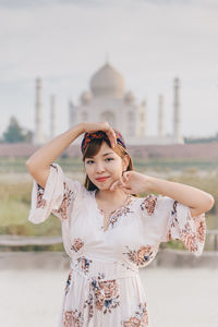 Portrait of woman standing against taj mahal