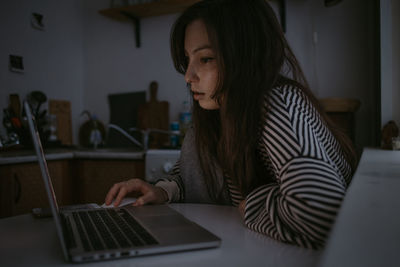 Young woman using laptop at home in the night