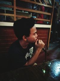 Young man looking away while sitting in restaurant