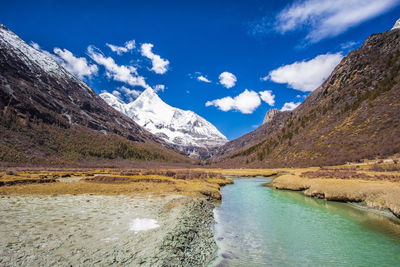 Scenic view of mountains against blue sky during winter