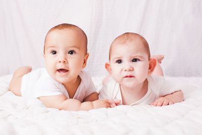 Portrait of cute baby lying on bed