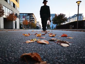 Man walking on leaves in city