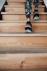 Low section of woman standing on wooden steps