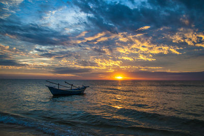 Silhouette boat in sea against sky during sunset