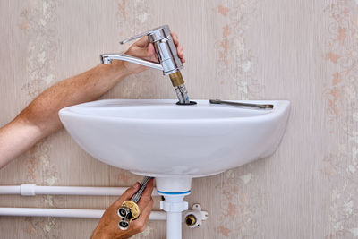 Cropped hand washing hands in bathroom