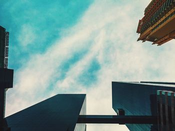 Low angle view of modern building against cloudy sky