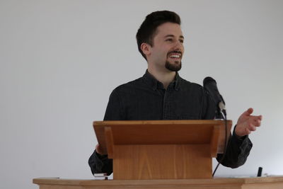 Young man looking away against white background