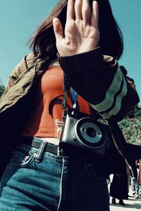 Woman photographing against blue sky
