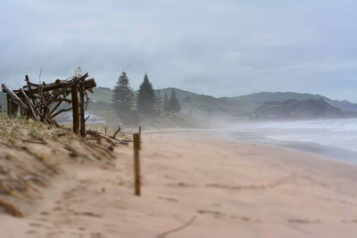 Scenic view of beach against cloudy sky