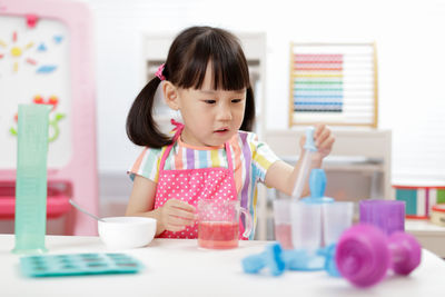 Close-up of boy playing with toy blocks while sitting on table