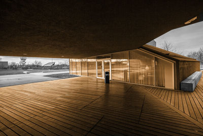 Empty swimming pool by building against sky