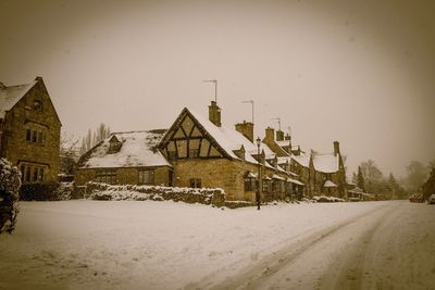 Road by building against clear sky during winter